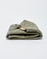 Tapis à langer couleur sauge plié.