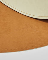 Tapis de cuir végan rond réversible tan et crème vue de près.